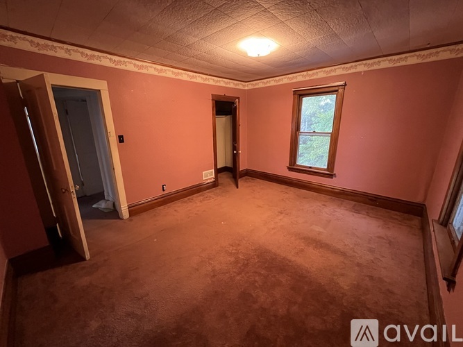 A room with a carpeted floor and a window.