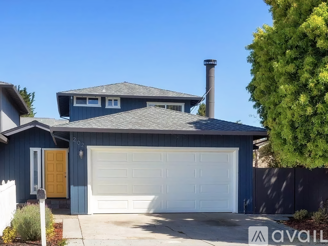 A house with a blue exterior and a white garage door.