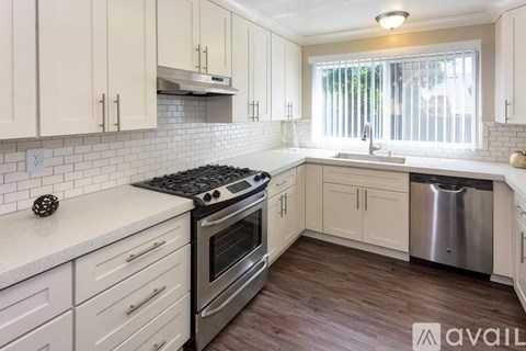 A kitchen with white cabinets and a stainless steel dishwasher.