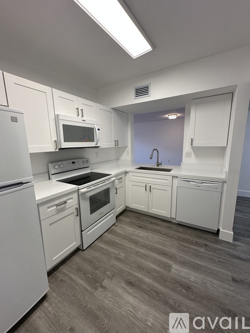 A kitchen with white appliances and cabinets.