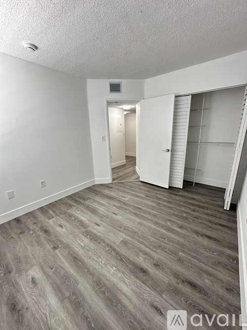 A room with wooden flooring and white walls.