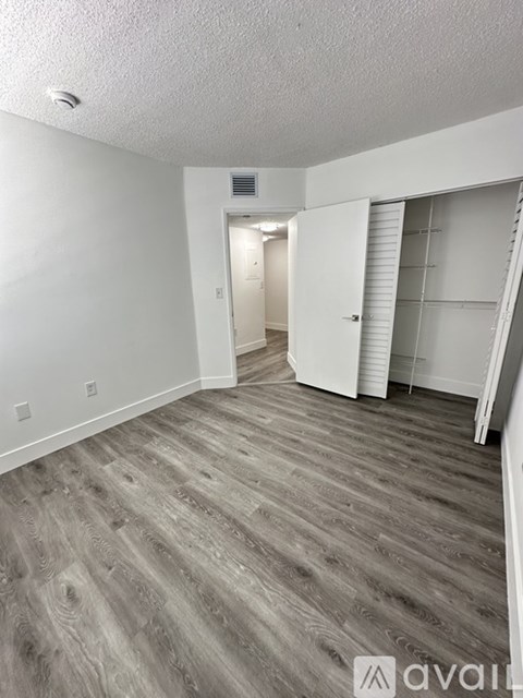 A room with wooden flooring and white walls.