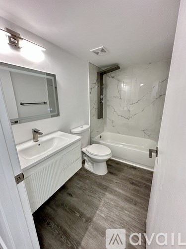 A bathroom with a white sink, toilet, and bathtub.