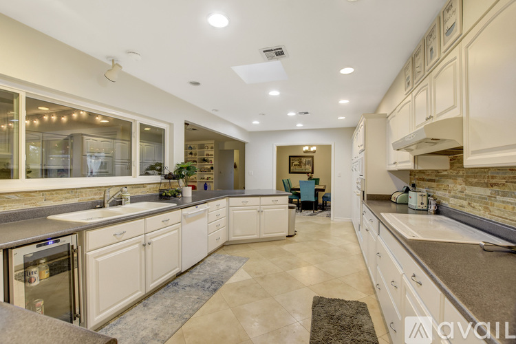 A spacious kitchen with white cabinets and a central island.
