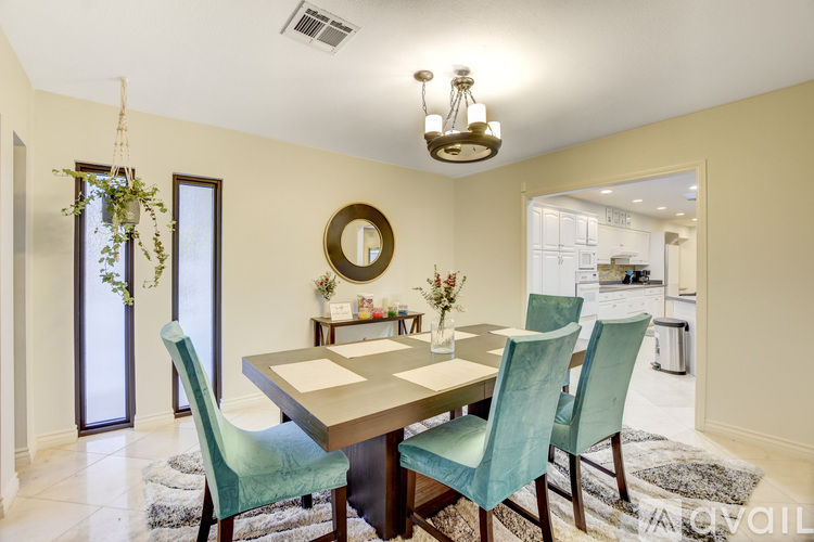 A dining room with a table and chairs.