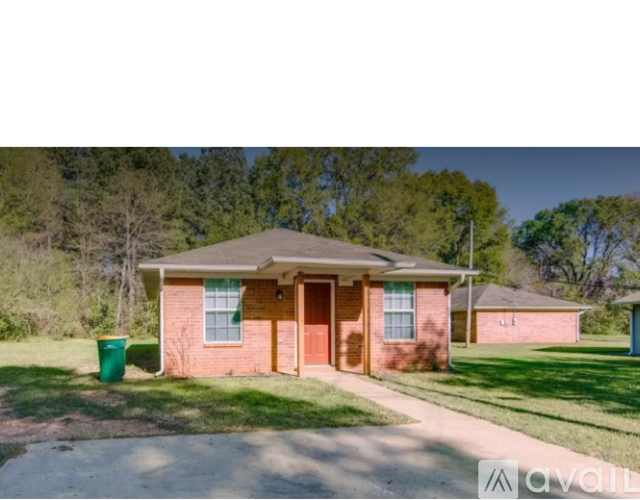 A house with a brown roof and a red door is for sale.