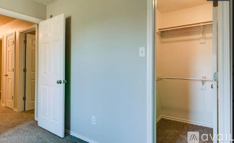 A white door is open to a small bedroom with a closet.