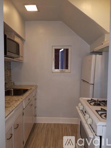 A kitchen with a stove, sink, and cabinets.