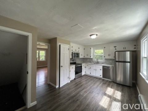 A kitchen with a refrigerator, sink, and cabinets.