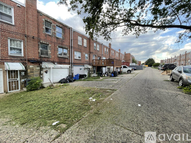 A street view of a residential area with brick buildings and parked cars.