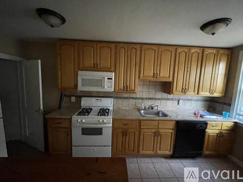 A kitchen with wooden cabinets and a white stove top oven.