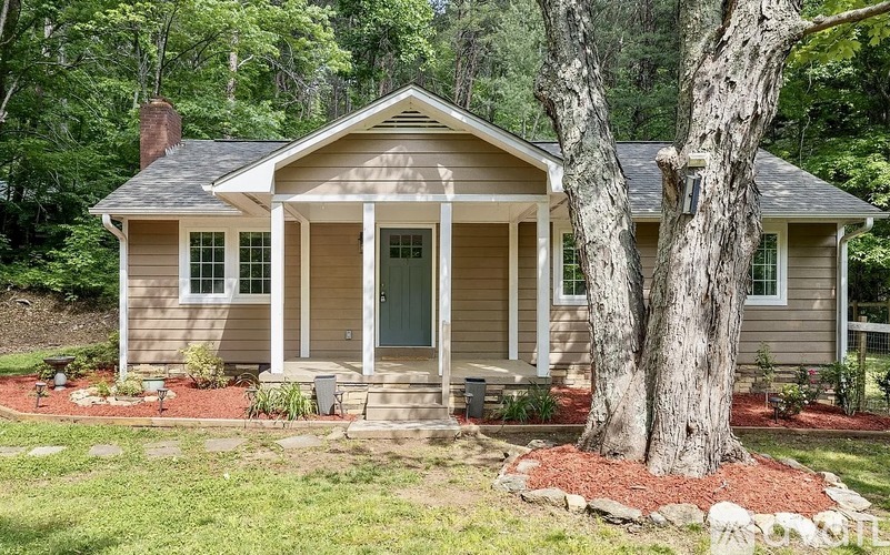 A small house with a tree in front.