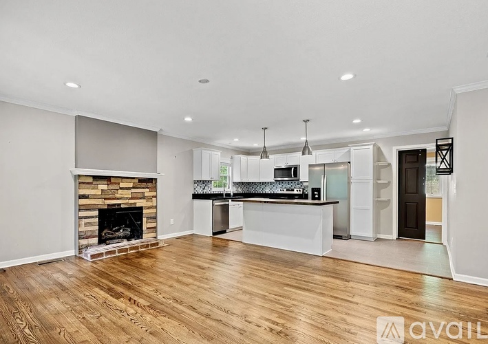 A modern kitchen with a fireplace and wooden floors.