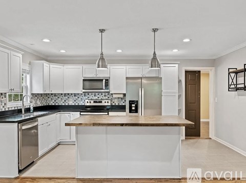 A modern kitchen with white cabinets and a central island.