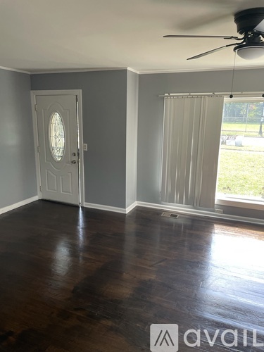 A room with a wooden floor and a ceiling fan.