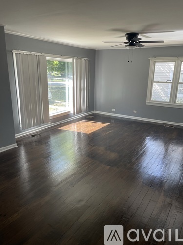 A room with wooden floors and a ceiling fan.