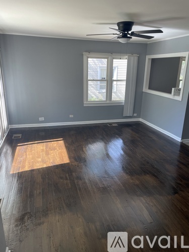 A room with a wooden floor and a ceiling fan.