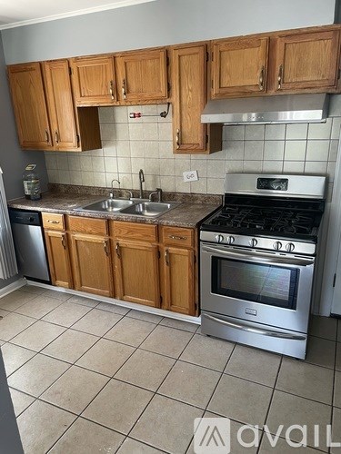 A kitchen with wooden cabinets and a stainless steel oven.
