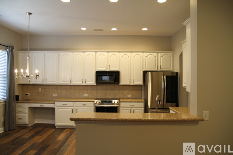 A kitchen with white cabinets and a brown countertop.