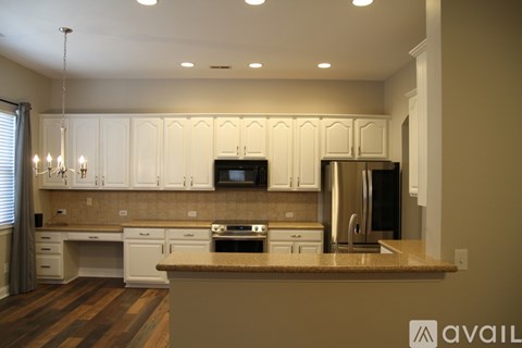 A kitchen with white cabinets and a brown countertop.