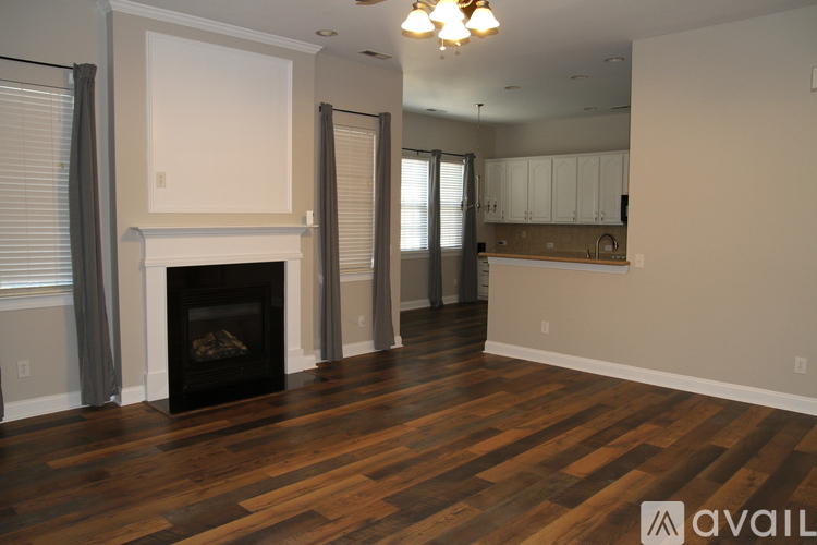 A living room with a fireplace and wooden floors.