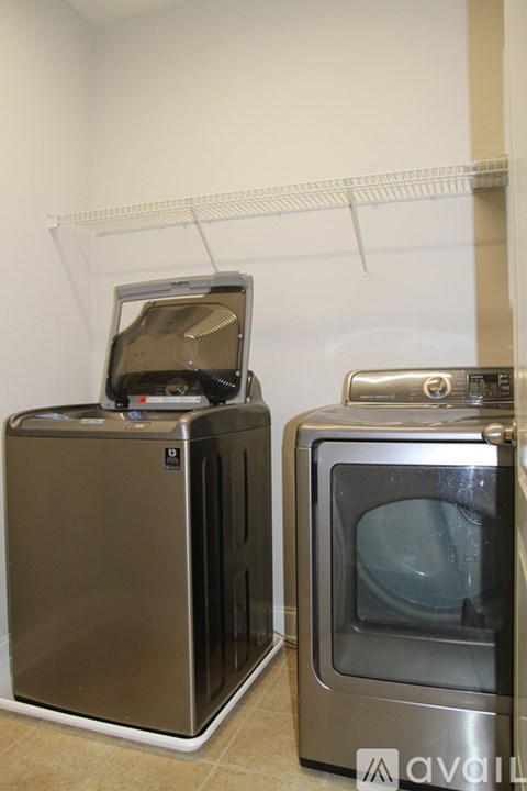 A stainless steel oven and microwave are on a white shelf.