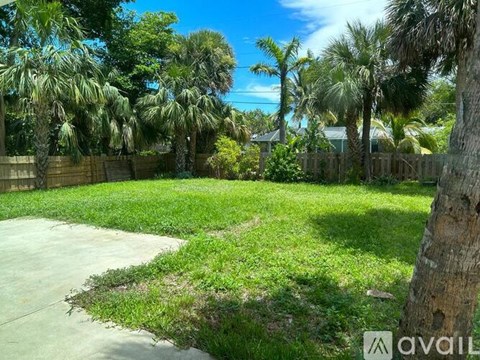 A backyard with a concrete slab and a fence.