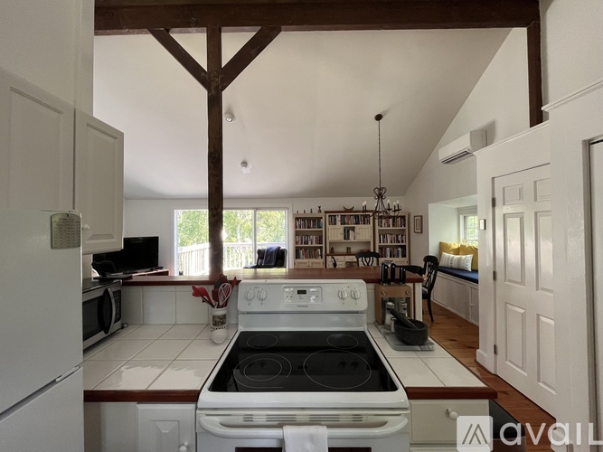 A kitchen with a white stove top oven and a white fridge.