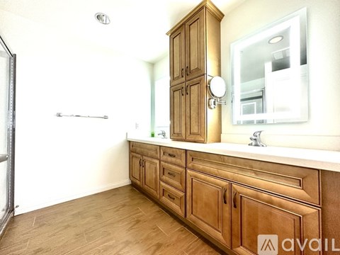 A wooden bathroom vanity with a mirror and a cabinet.