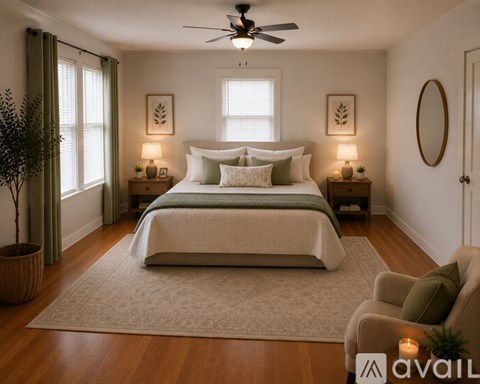 A bedroom with a large bed and a ceiling fan.
