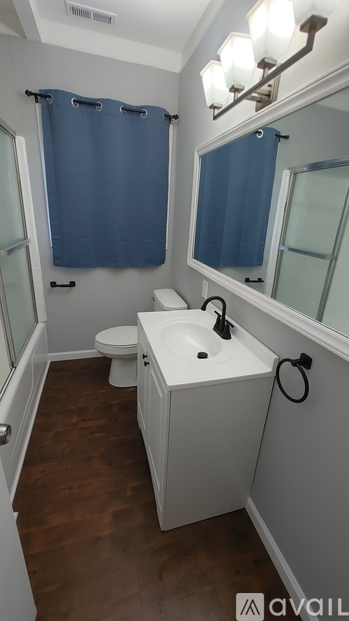 A small bathroom with a toilet, sink, and shower curtain.
