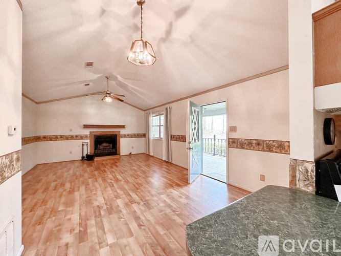 A living room with wood flooring and a fireplace.