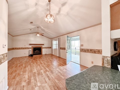 A living room with wood flooring and a fireplace.