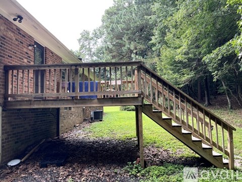 A wooden staircase leads up to a balcony.