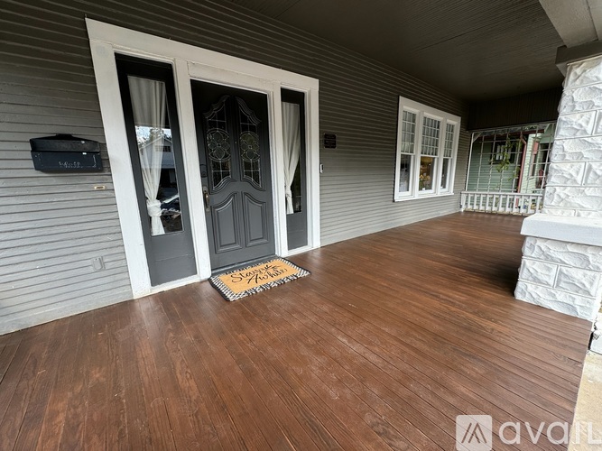 A house entrance with a wooden floor and a door with a glass panel.