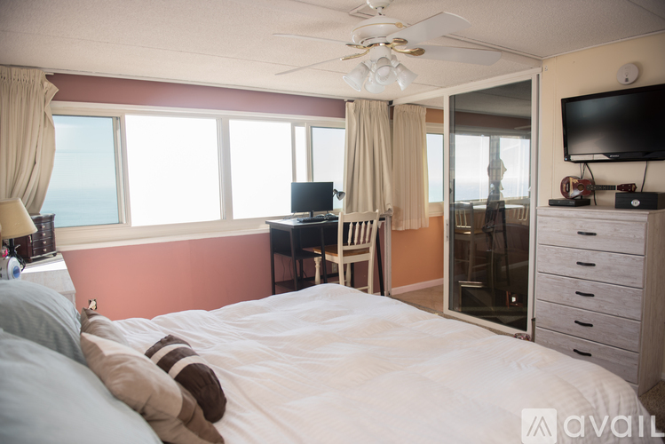 A bedroom with a large bed and a television on the wall.