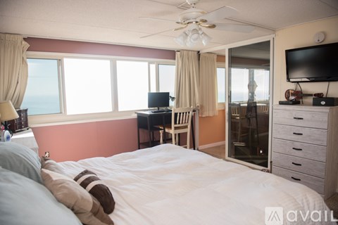 A bedroom with a large bed and a television on the wall.