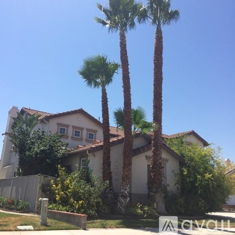 A house with a white fence and a sign that says "AVOLL".