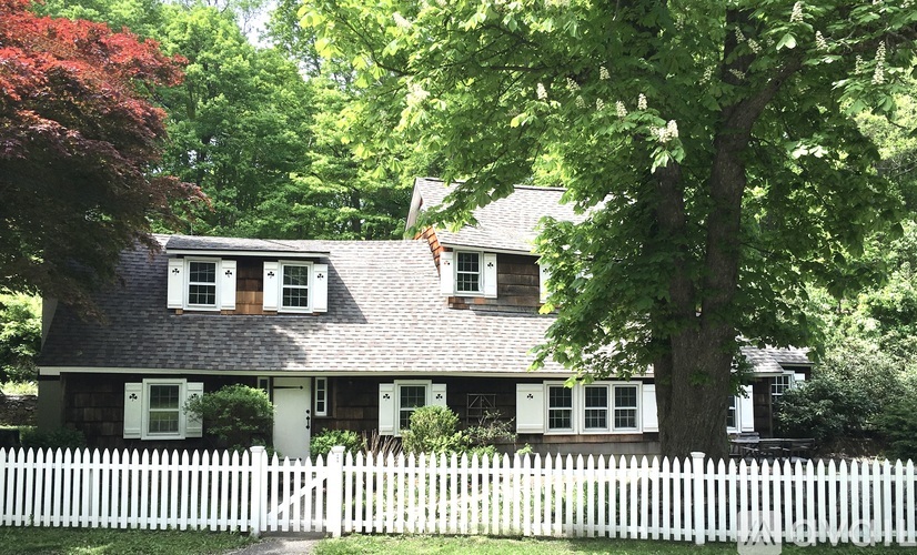A house with a white picket fence in front of it.