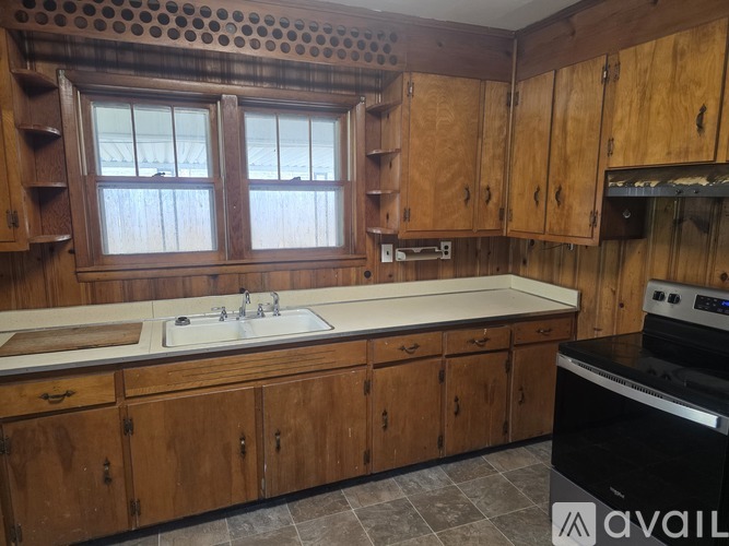 A kitchen with wooden cabinets and a window.