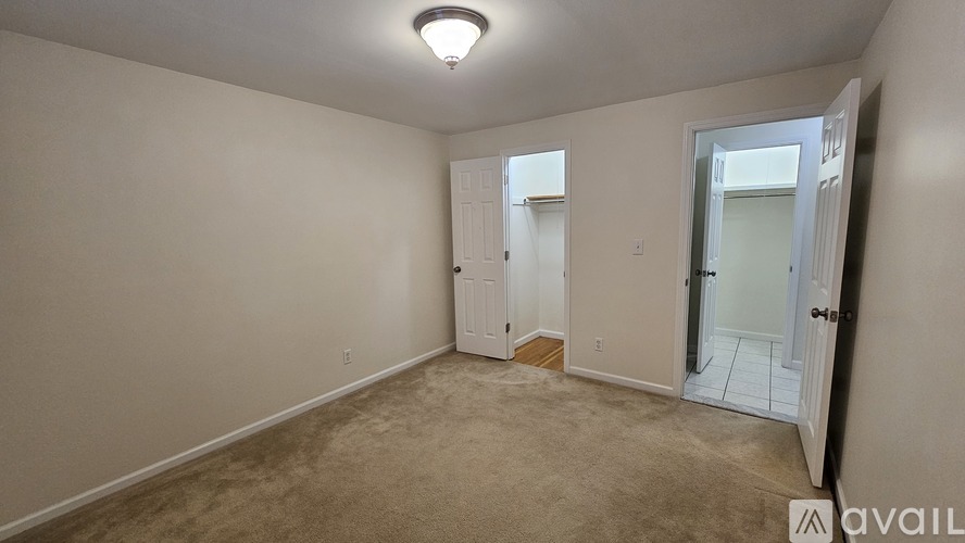 A room with a carpeted floor and a ceiling light.