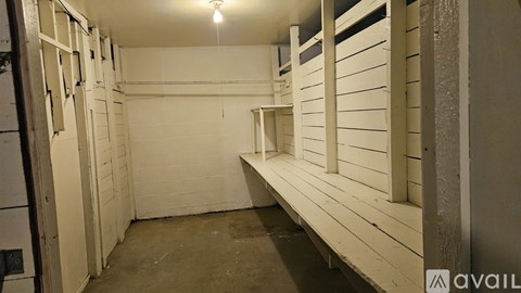A white room with a bench and a door.