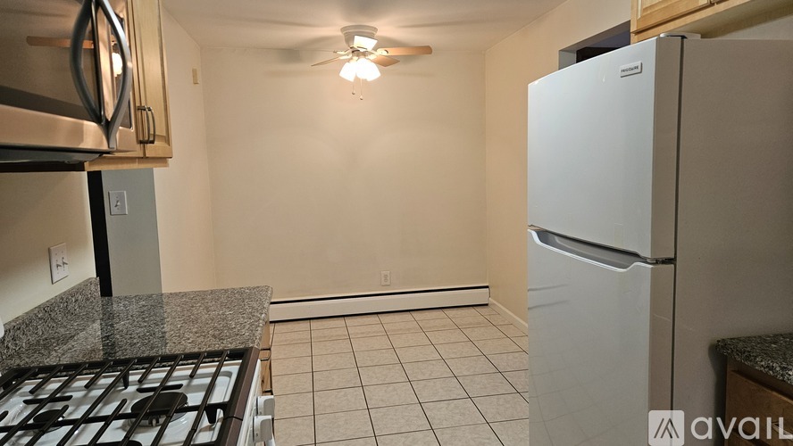 A kitchen with a white fridge and a black stove top.