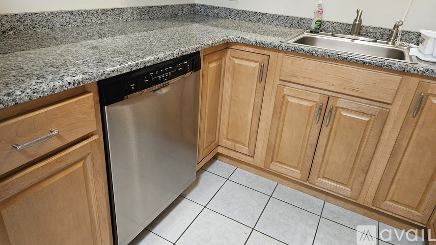 A kitchen with wooden cabinets and a granite countertop.