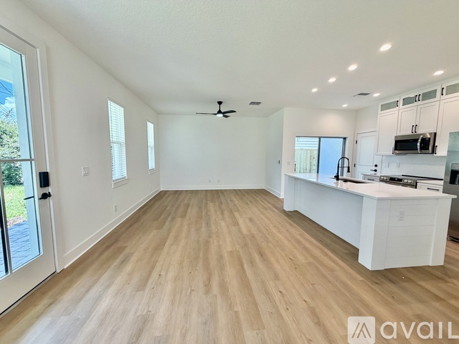 A spacious room with wooden flooring and a ceiling fan.