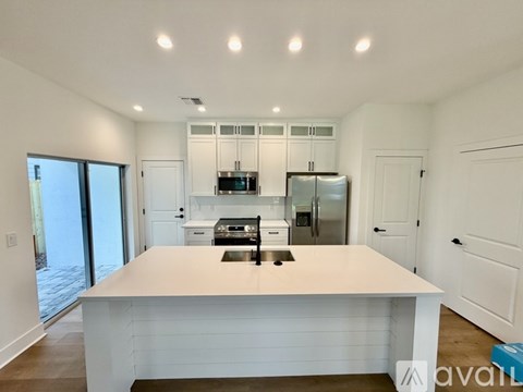 A kitchen with white cabinets and appliances is available for rent.