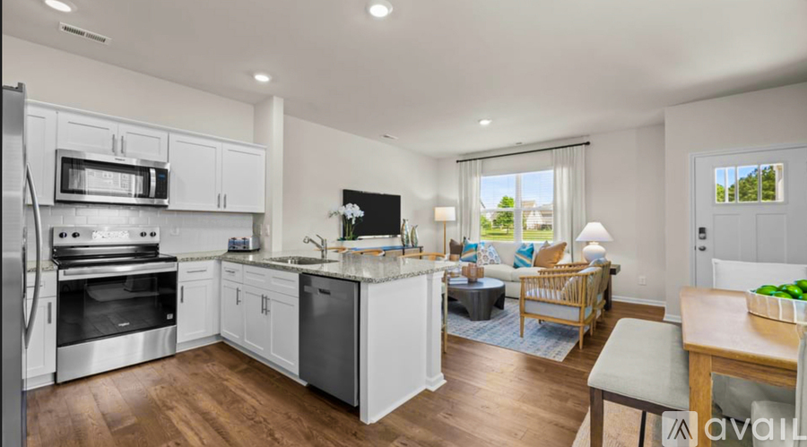 A modern kitchen with white cabinets and stainless steel appliances.