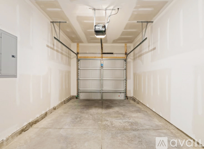 A spacious garage with a metal shelving unit and a hanging light fixture.