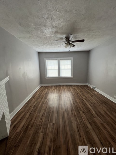 A room with wooden floors and a ceiling fan.