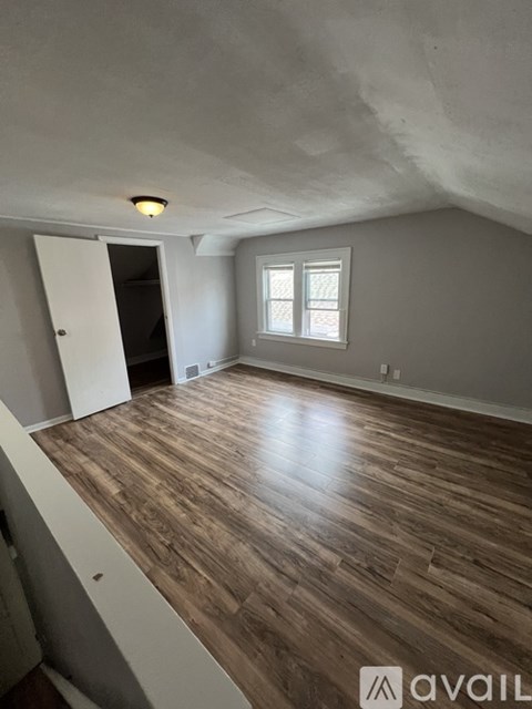 A room with wooden flooring and a window.